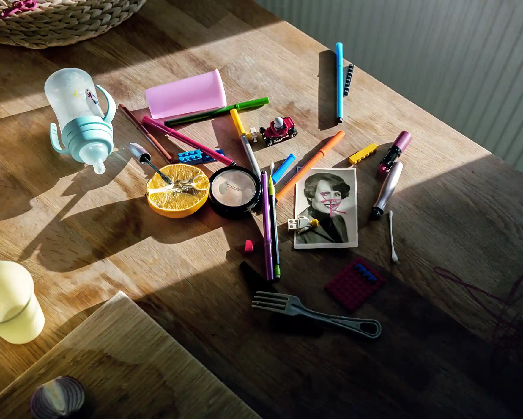 table with crayons and milk bottle and other kid mess