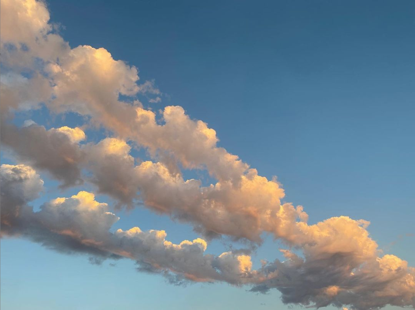 pink light under the clouds in a blue sky