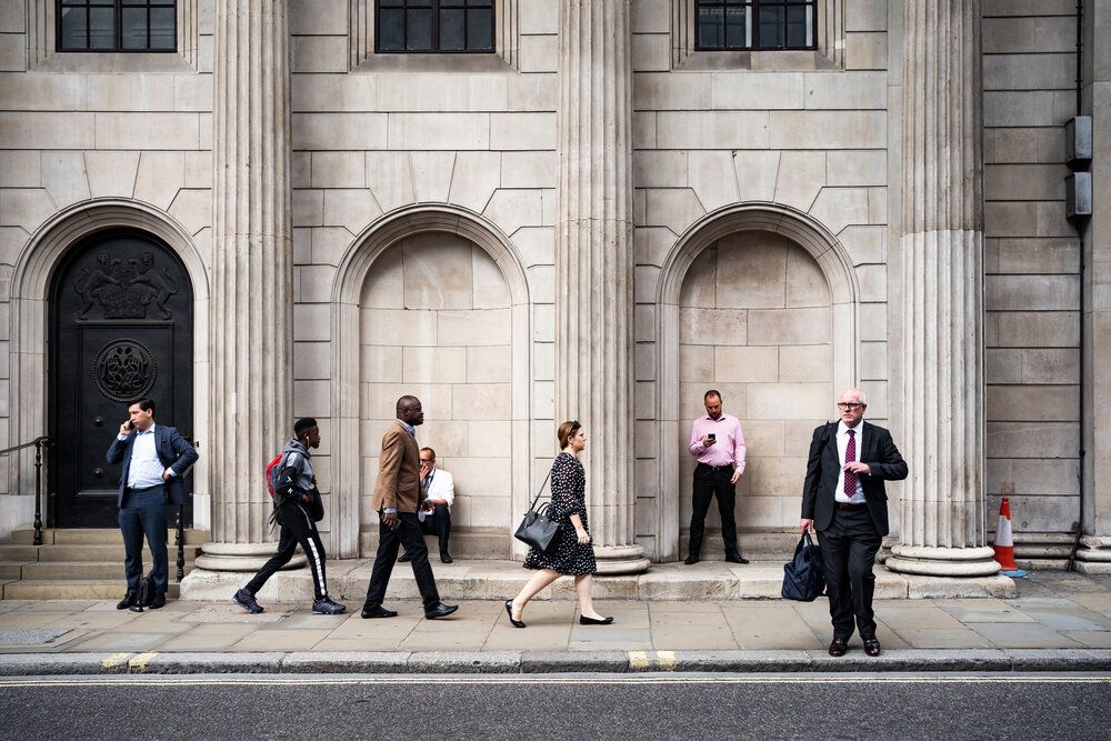 Street view of seven people, sharing a street, but seemingly in their own worlds.