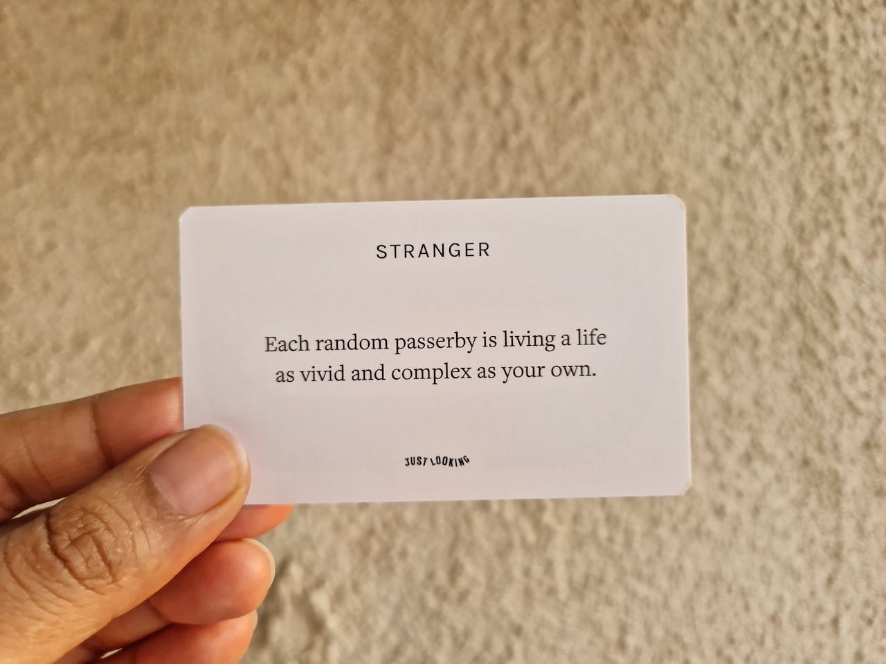 A card with text: Stranger - Each random passerby is living a life as vivid and complex as your own.