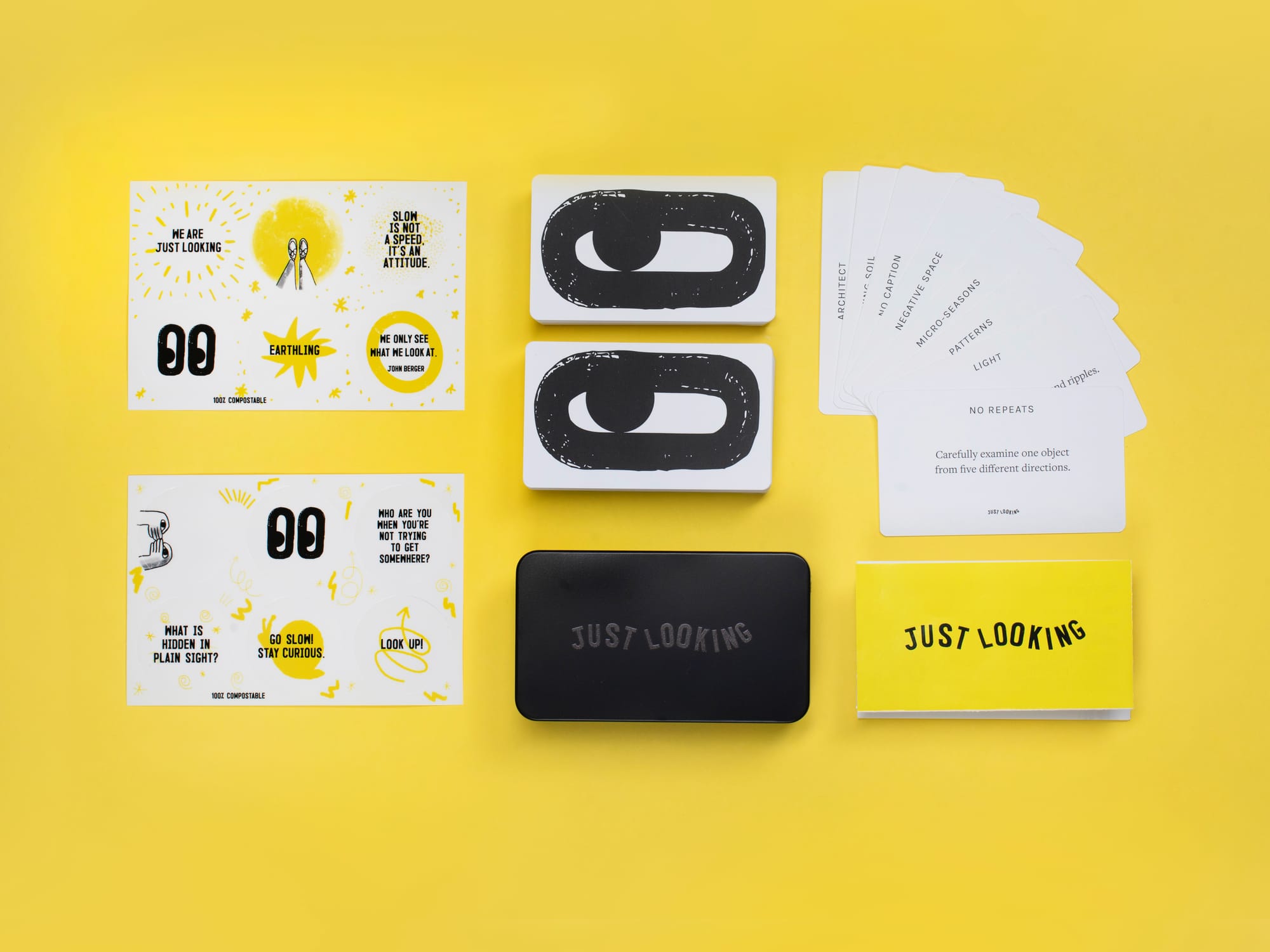 Product photo: Cards, stickers, concertina and a black tin on a yellow background